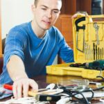 handsome man with toolbox reaching hammer